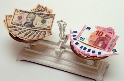 A picture illustration shows U.S. Dollar and Euro banknotes on a pair of scales in Vienna March 11, 2015. The battered euro took another plunge toward parity with the dollar on Wednesday, shedding over 1 percent to trade below $1.06 for the first time in 12 years as a 1.1 trillion euro bond-buying program began to bite.  REUTERS/Heinz-Peter Bader (AUSTRIA  - Tags: BUSINESS)