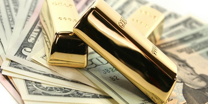 Three large gold bars on many dollar bills